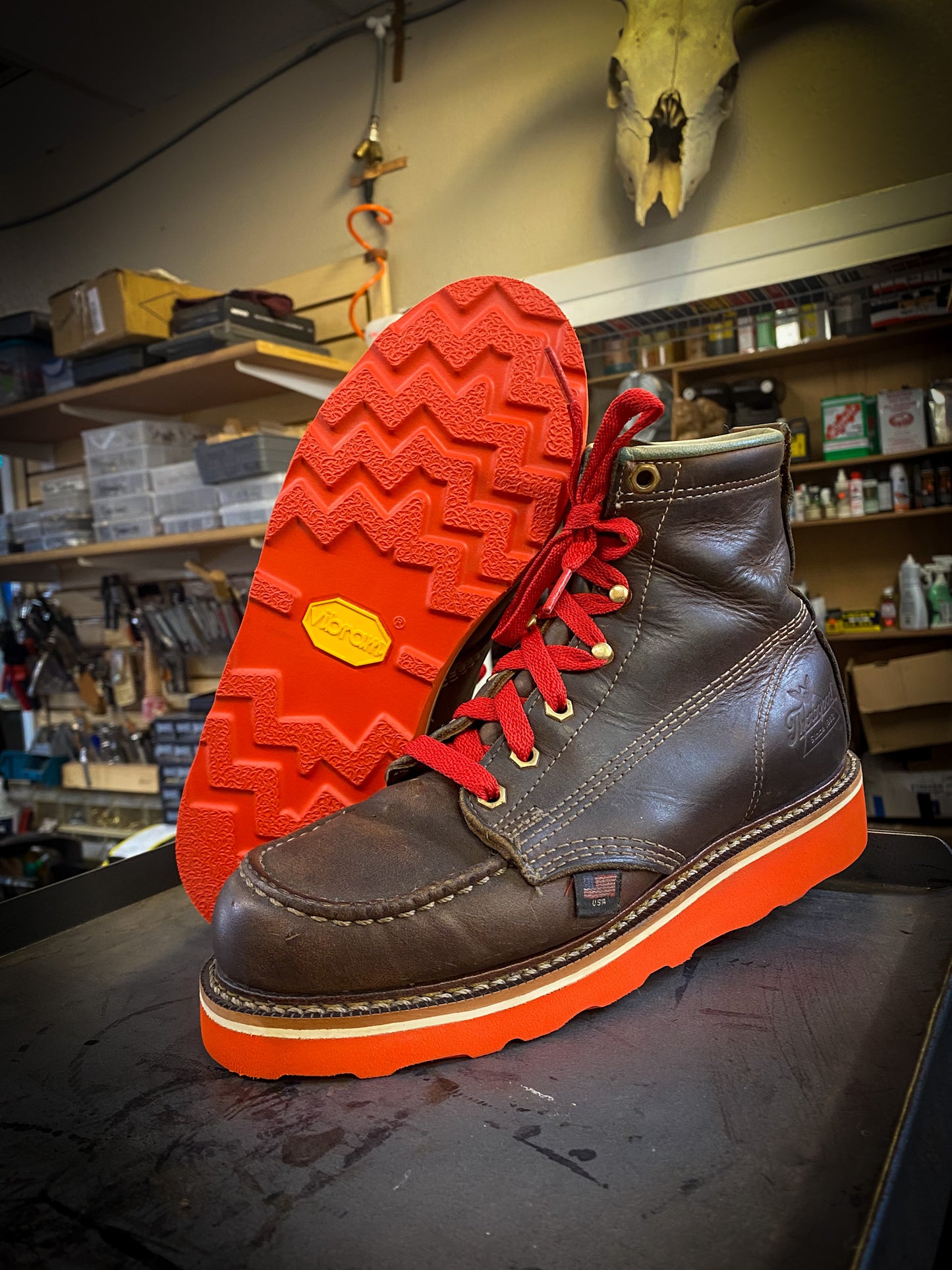a pair of Thorogood work boots after being repaired with new Red Vibram wedge soles at the boot repair center