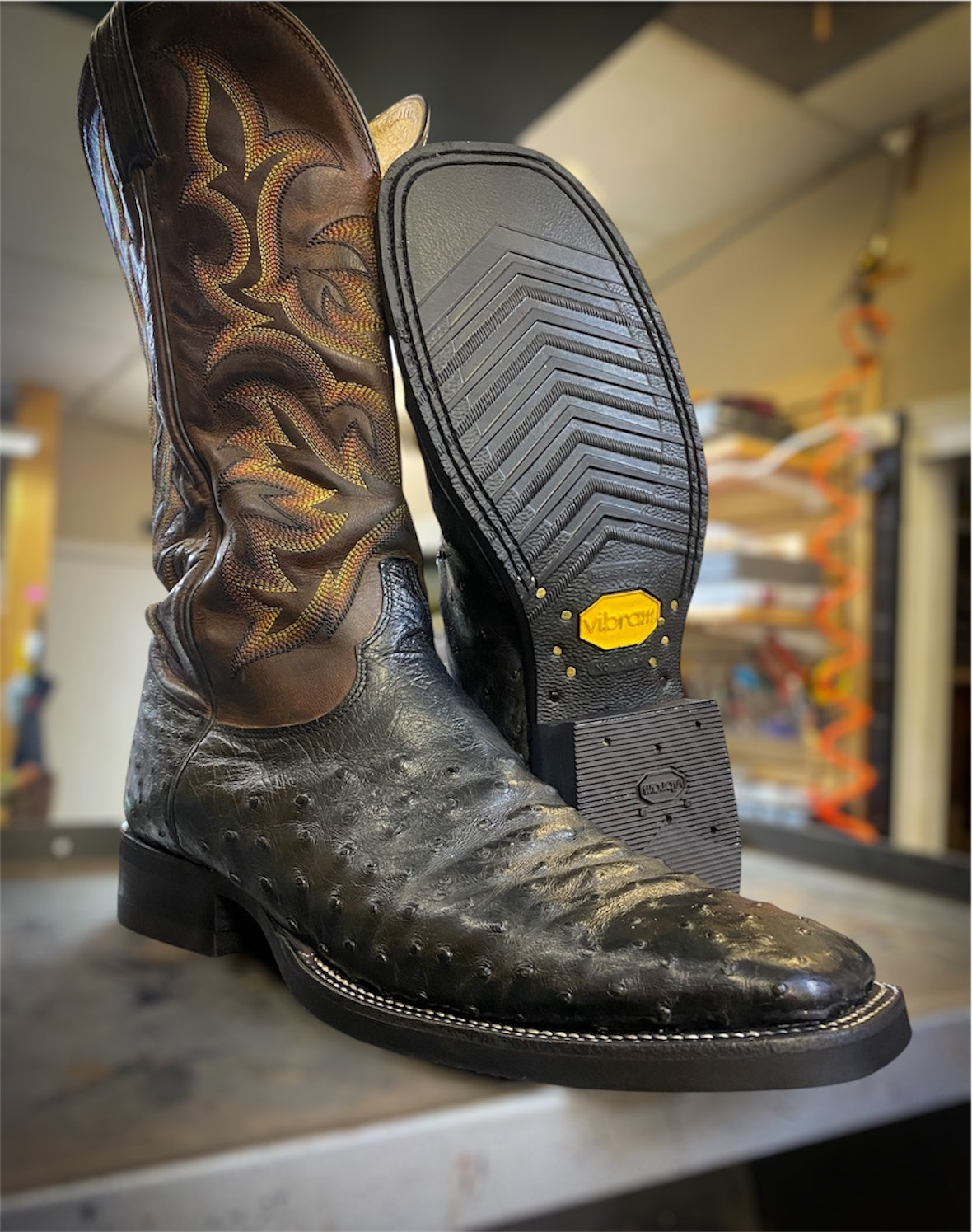 A pair of Black Ostrich Skin Cowboy Boots Resoled With New Black Vibram 700 Tygum Soles