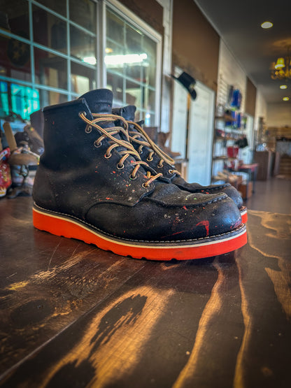 a pair of Redwing Moc-toe work boots after being repaired with new Red Vibram wedge soles at the Redwing Boot repair center