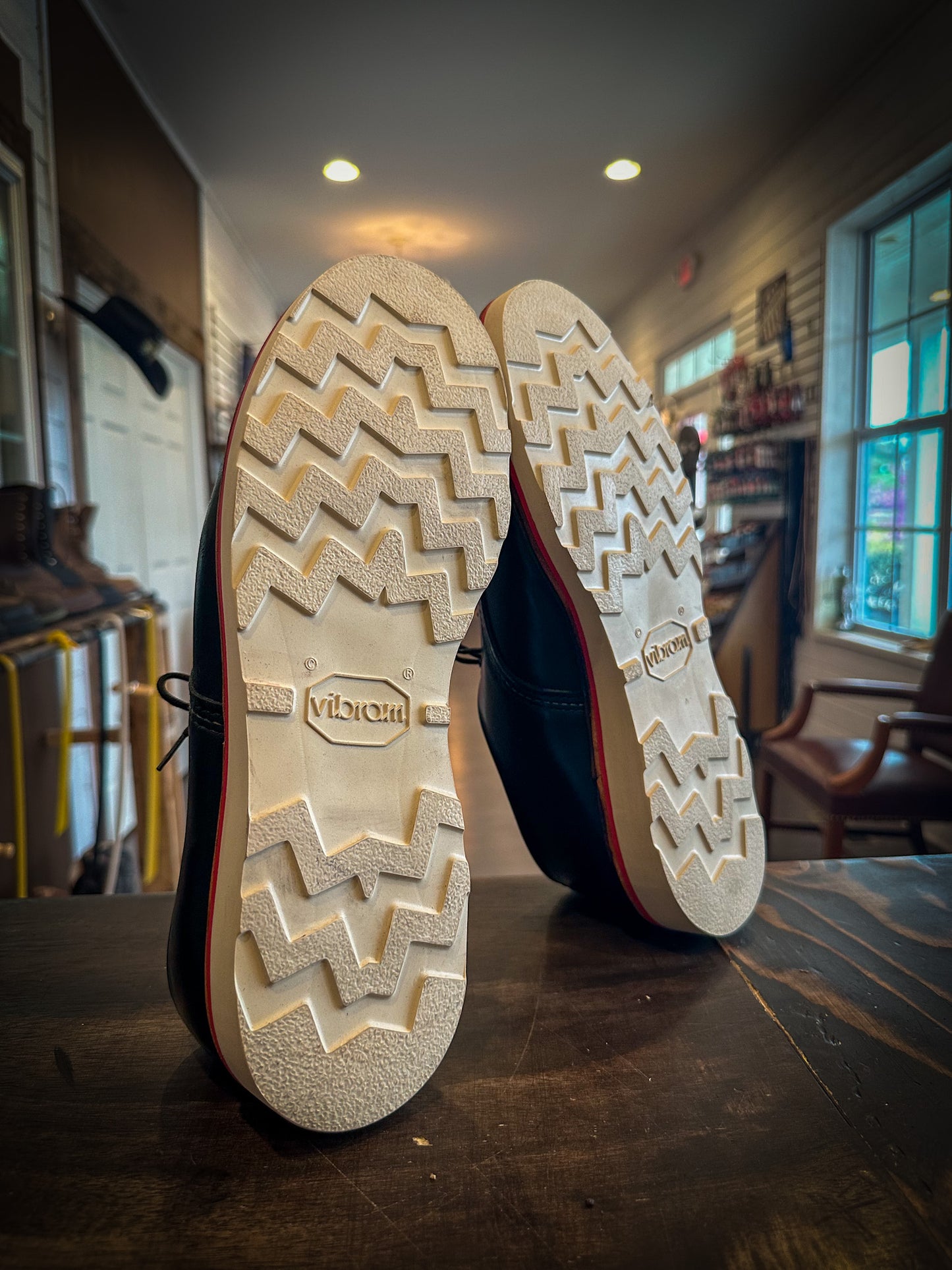 A pair of redwing shoes after being repaired with new Vibram wedge soles and a red midsole at the Redwing Boot Repair Center