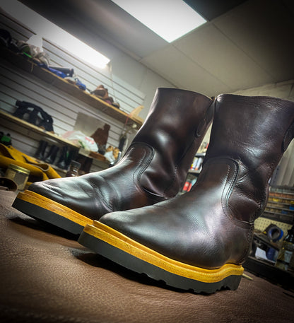 a pair of pull on work boots after being repaired with new Vibram wedge soles at the boot repair center