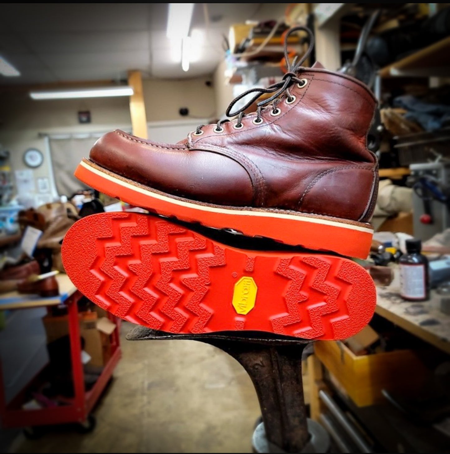 a pair of Redwing Moc-toe work boots after being repaired with new Red Vibram wedge soles at the Redwing Boot repair center