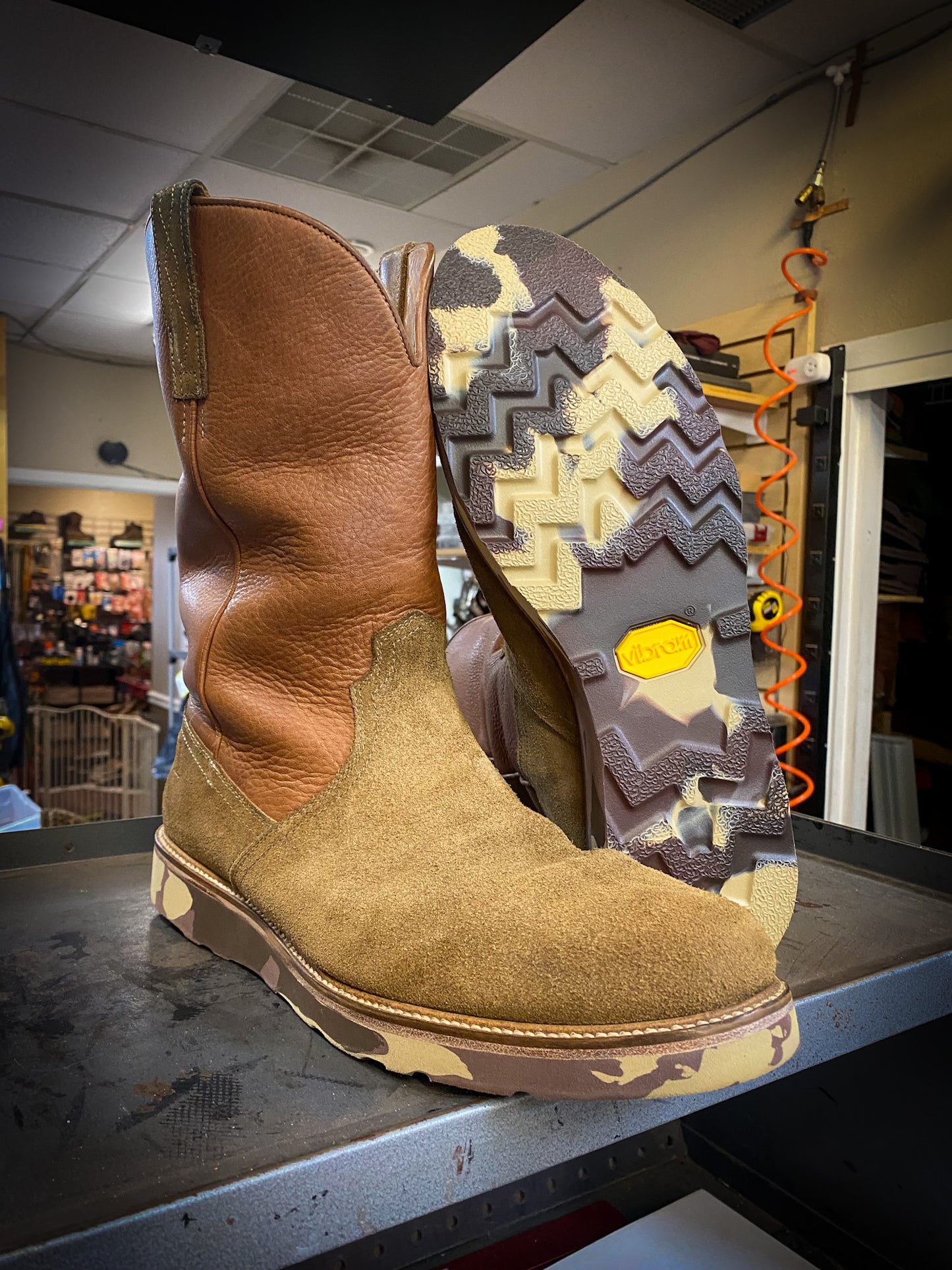 A pair of Lucchese Boots after being repaired with new Vibram camo wedge soles at the boot repair center