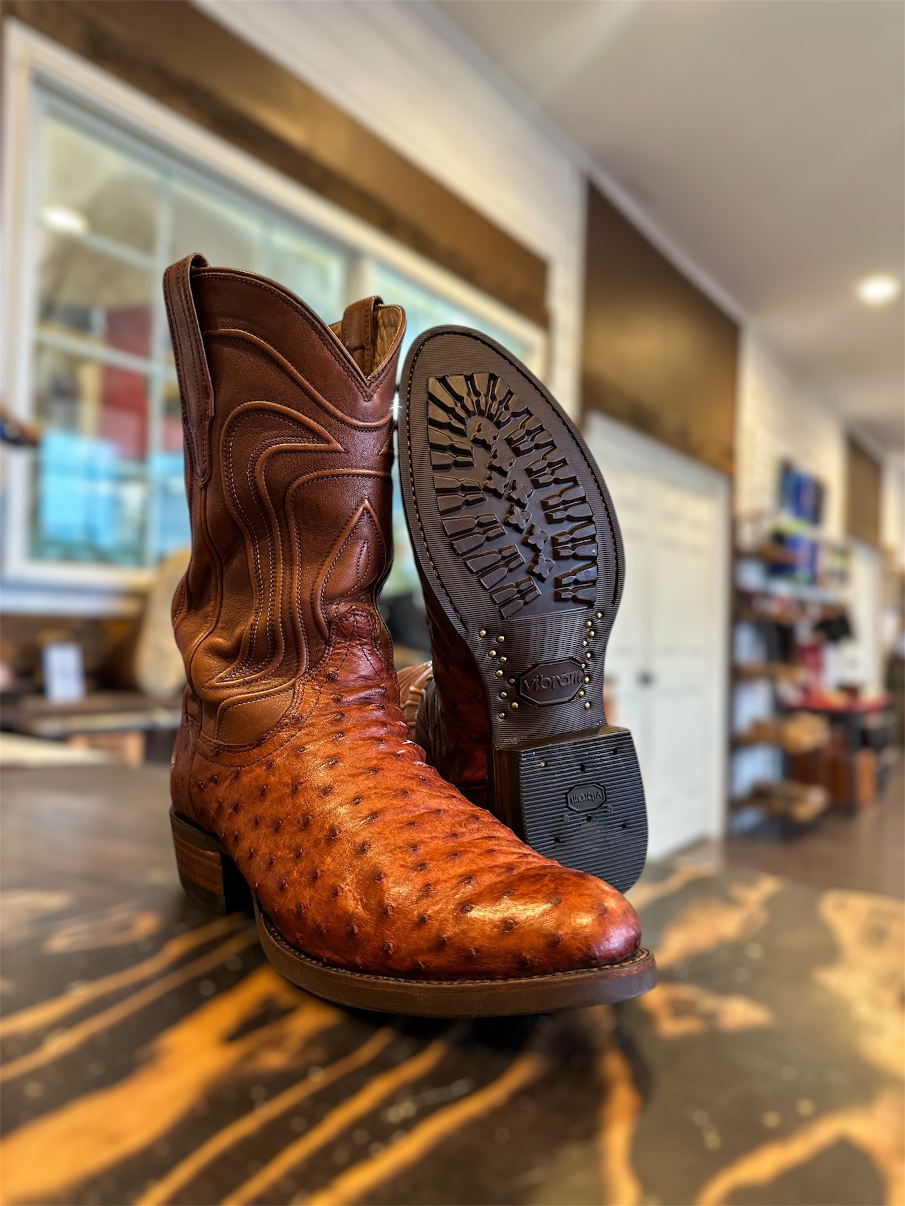 A pair of Tecovas Ostrich Skin Cowboy Boots Repaired with new Vibram 430 soles in brown