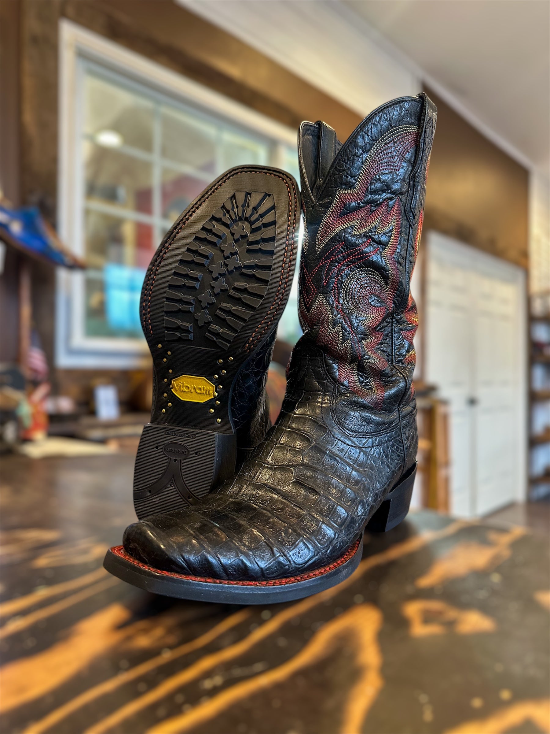 A pair of Black Ariat Caiman Skin Cowboy Boots Repaired with new Vibram 430 soles in black