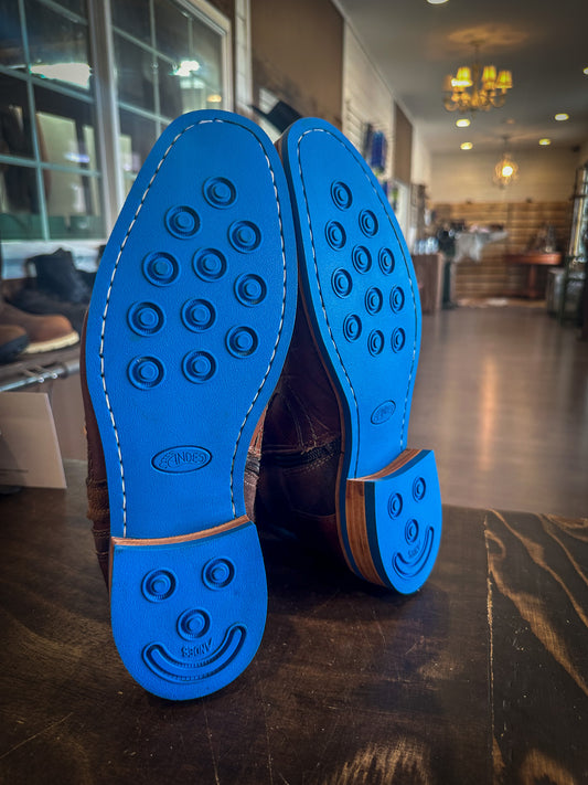 A pair of dress boots repaired with new Blue Andes Rubber Soles and Heels at the Boot repair center