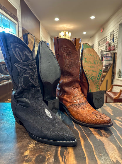 2 pairs of exotic skin cowboy boots after being repaired with new JR leather soles and rubber heels at the cowboy boot repair center 