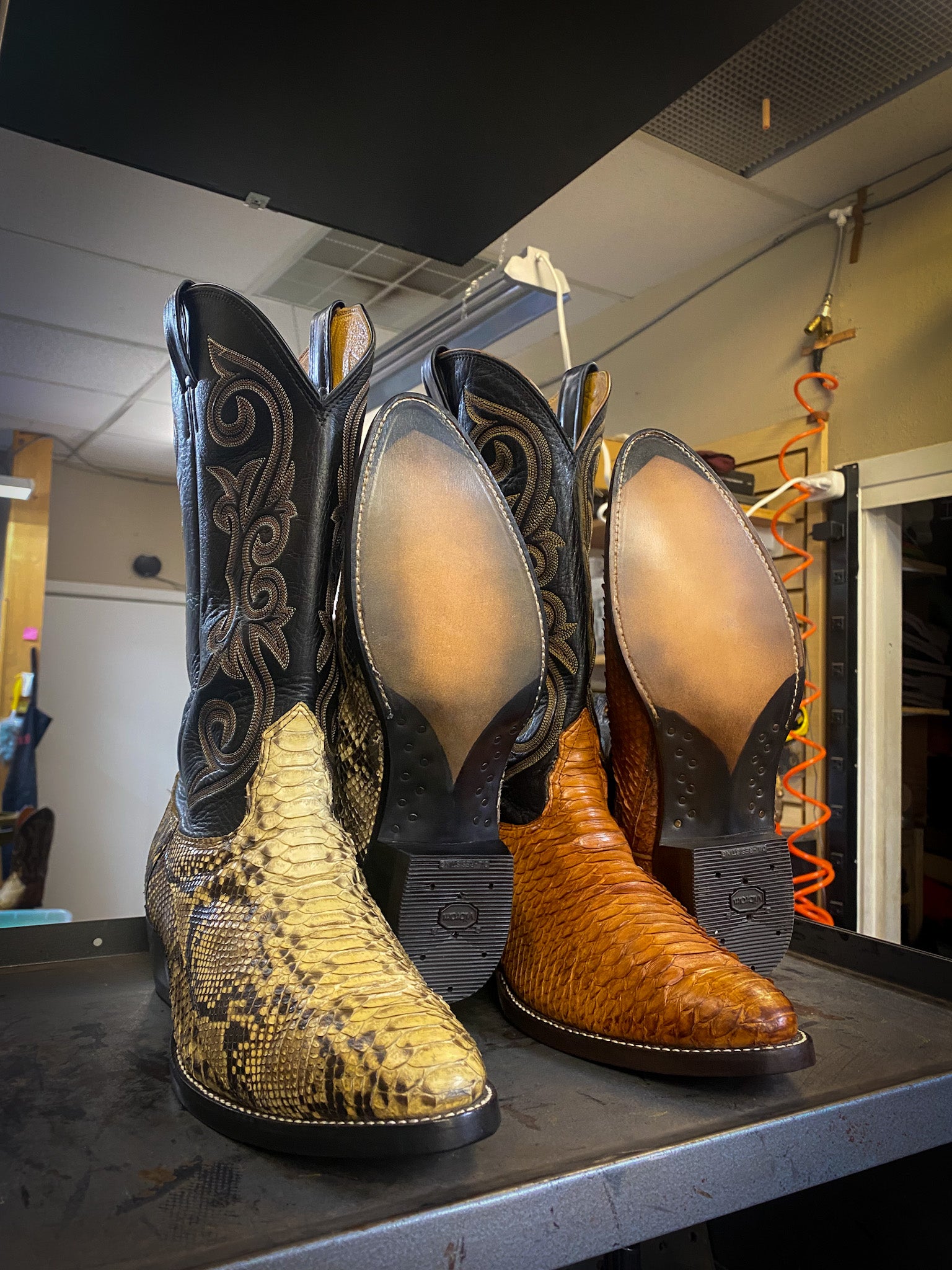 two pairs of vintage Dan Post cowboy boots after being repaired with new leather soles at the cowboy boot repair center