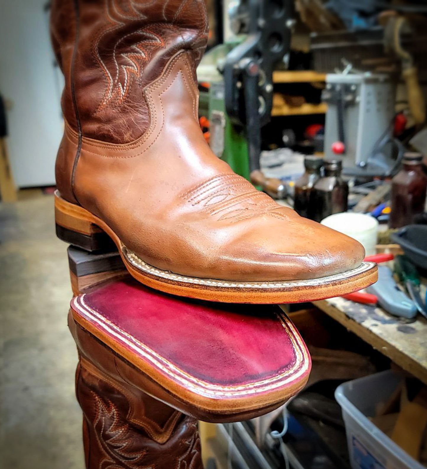 a pair of square toe cowboy boots repaired with new leather soles at the cowboy boot repair center