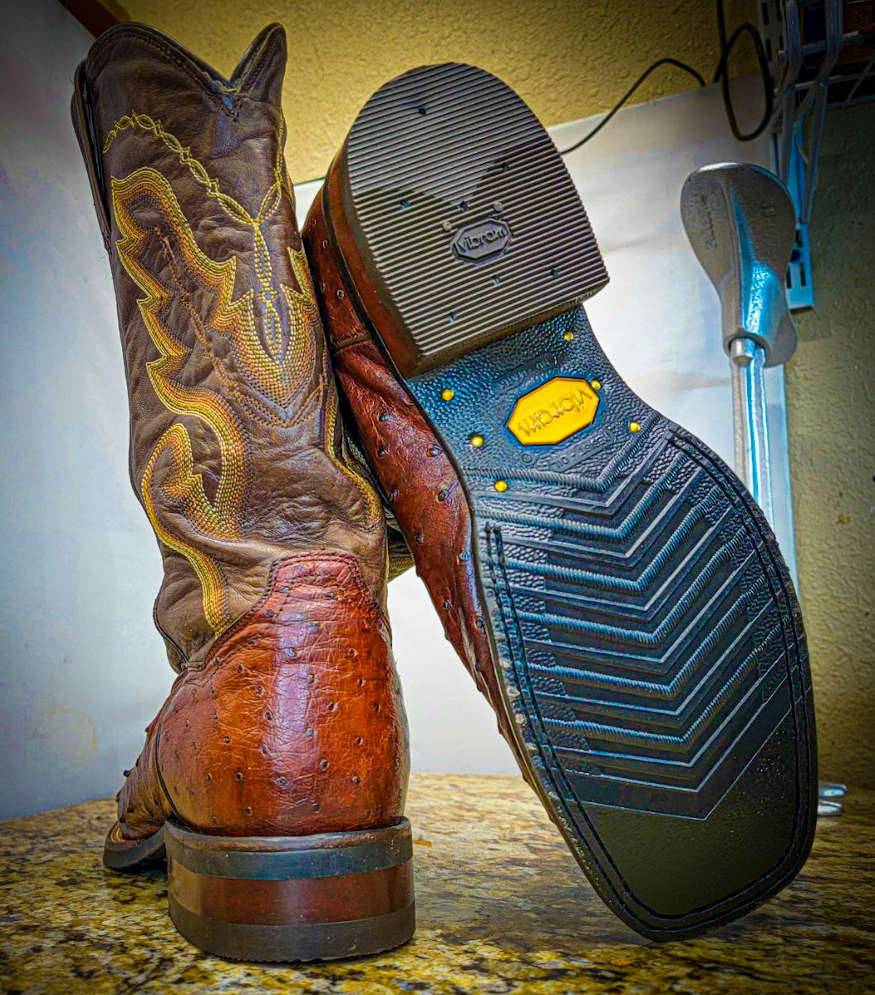 A pair of square toe Ostrich Skin Dan Post Cowboy Boots after being repaired with new Vibram 700 Soles and heels at The Cowboy Boot Repair Center