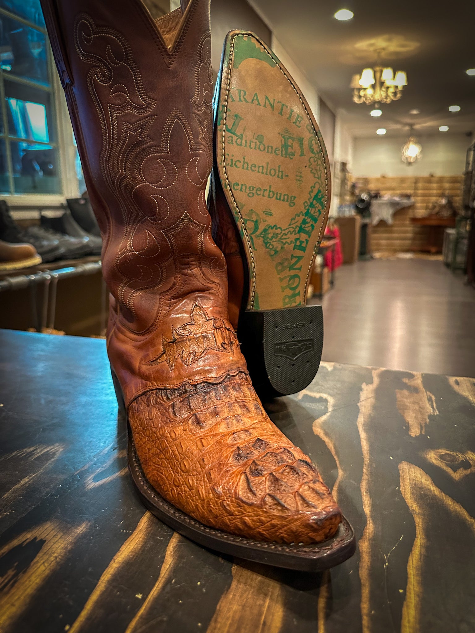 a pair of Caiman Skin Cowboy Boots after being repaired with new JR Graffiti soles and rubber heels at the cowboy boot repair center