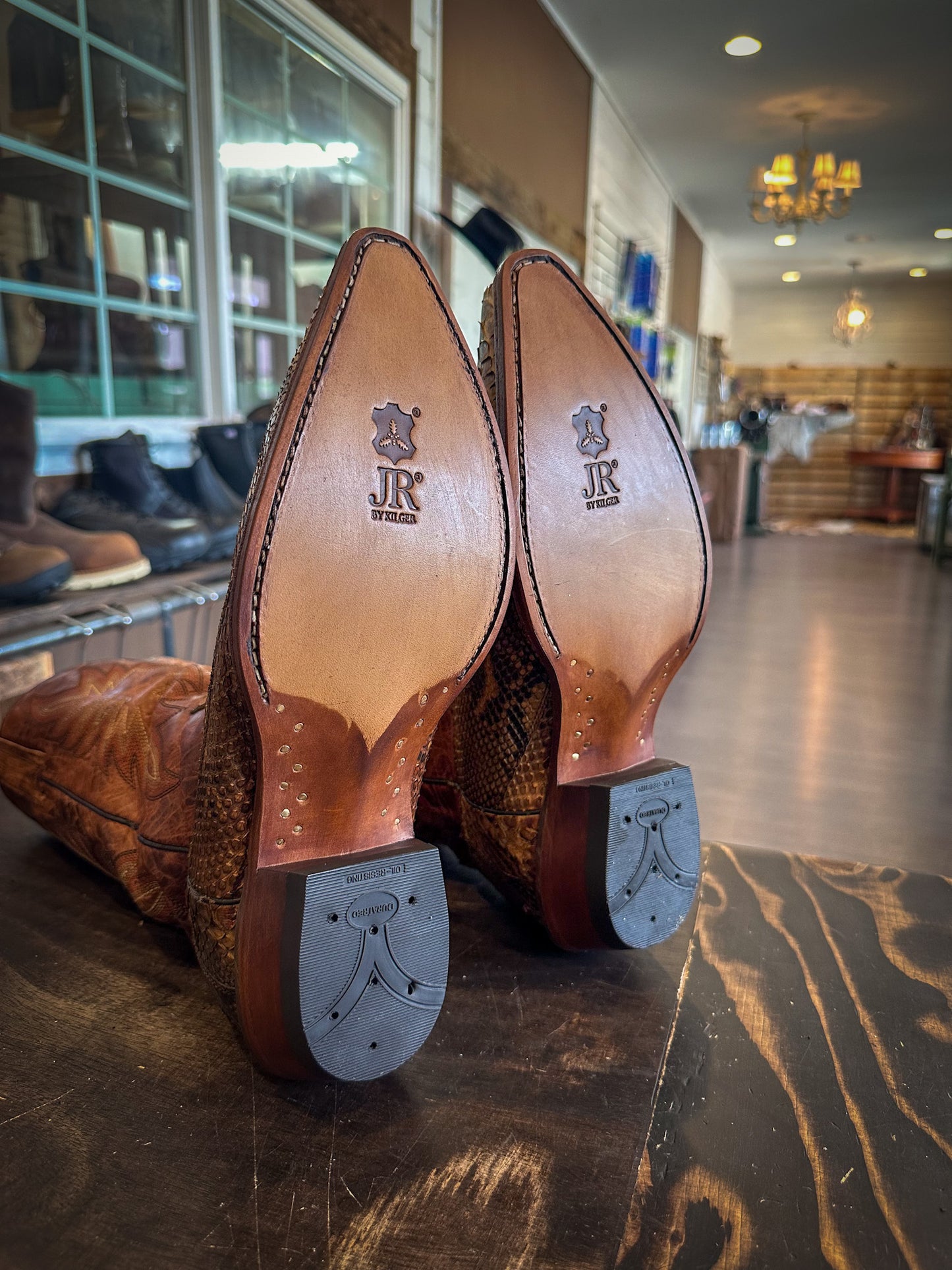 a pair of snake skin cowboy boots after being repaired with new JR leather soles and rubber heels at the cowboy boot repair center