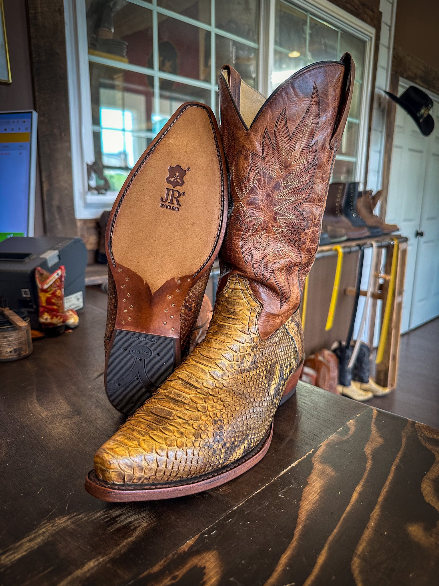 a pair of snake skin cowboy boots after being repaired with new JR leather soles and rubber heels at the cowboy boot repair center