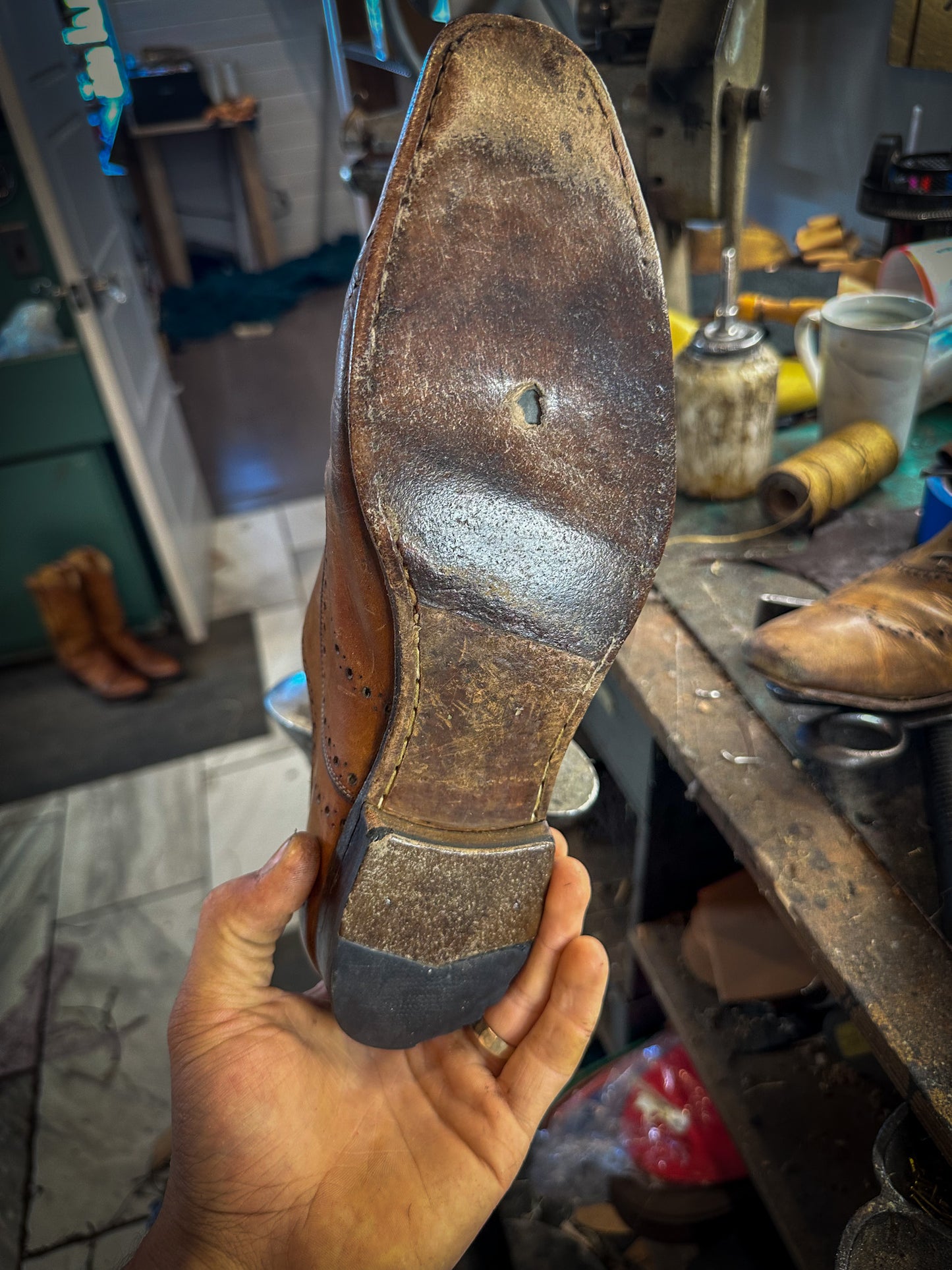 a pair of Ferragamo Dress shoes before being repaired with new leather soles at the dress shoe repair center 