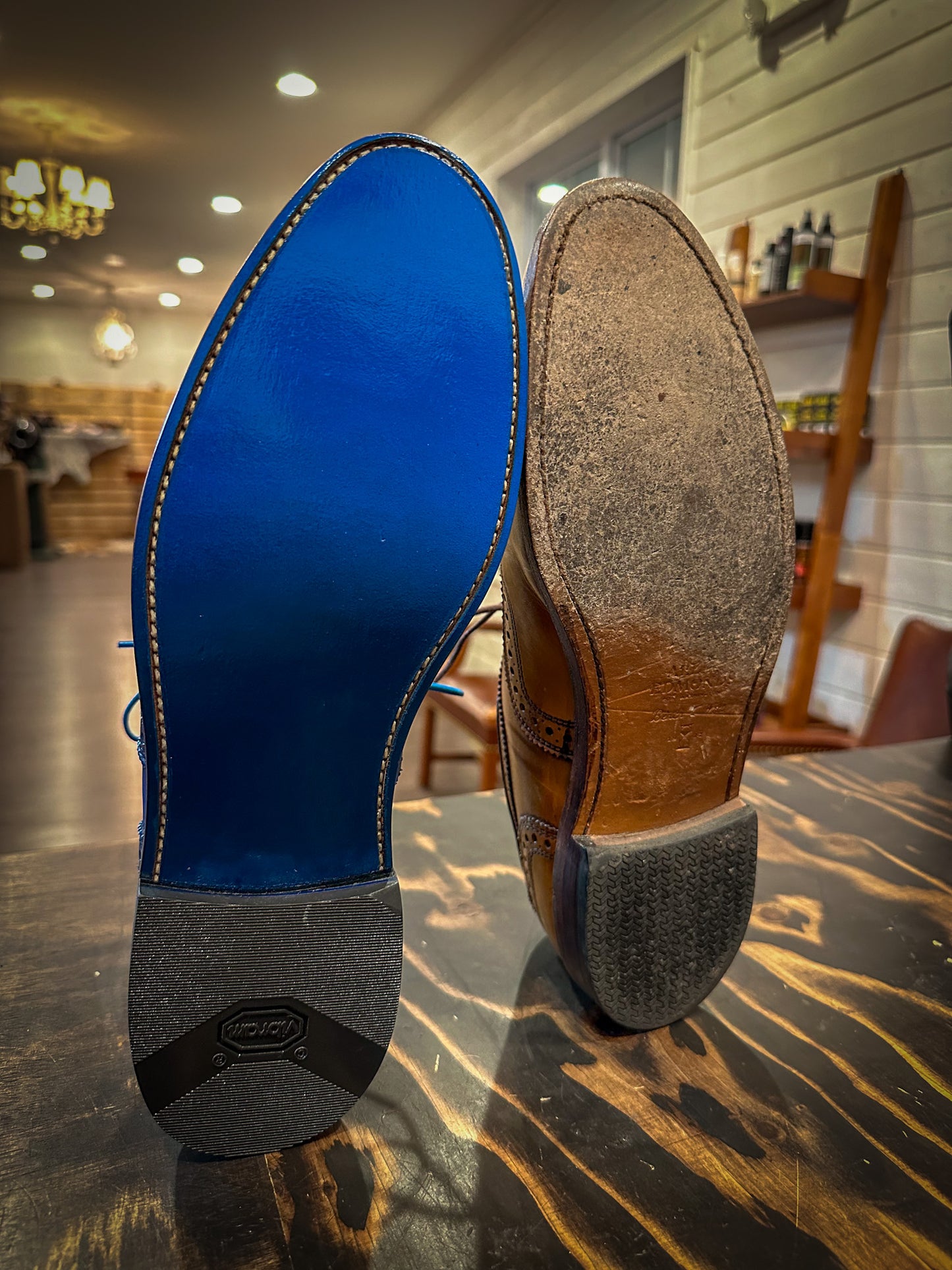 A pair of Allen Edmonds Walnut Strands Before and after being repaired with new leather soles at the dress shoe repair center