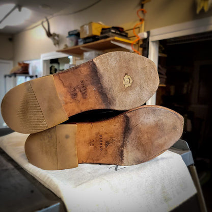 a pair of Nisolo dress shoes before being repaired with new leather soles at the dress shoe repair center