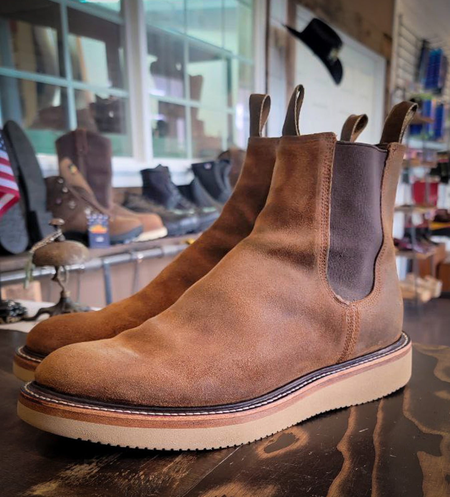 A pair of light brown Chelsea style boots after being repaired with new Vibram Wedge soles at The Boot Repair Center