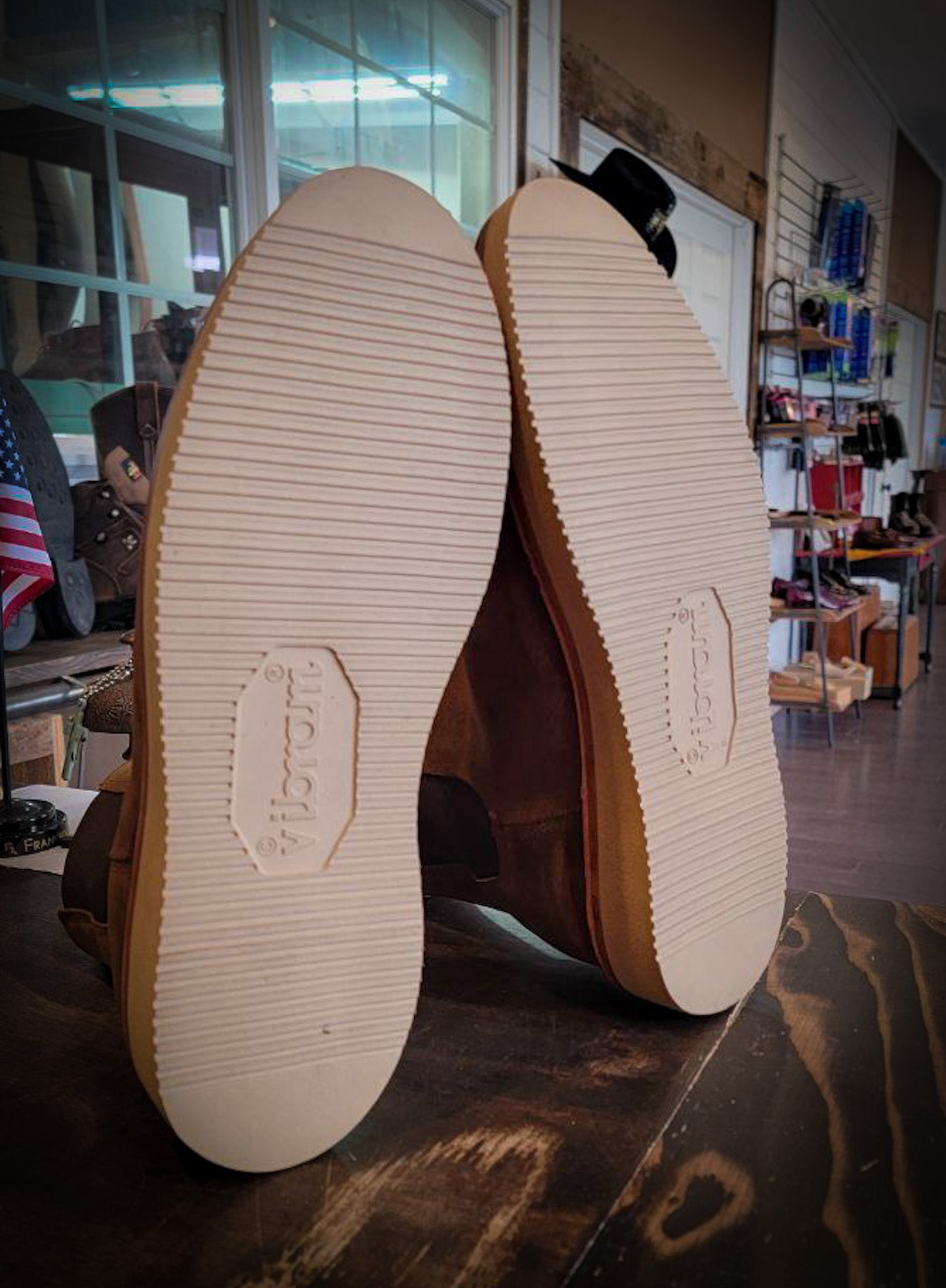 A pair of light brown Chelsea style boots after being repaired with new Vibram Wedge soles at The Boot Repair Center