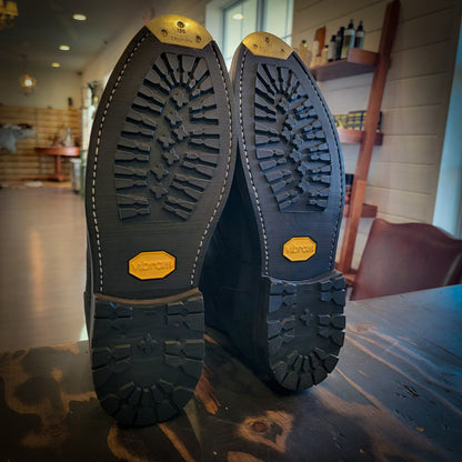 a pair of Thursday boots after being repaired with new Vibram 430 Mini Lug soles at the boot repair center