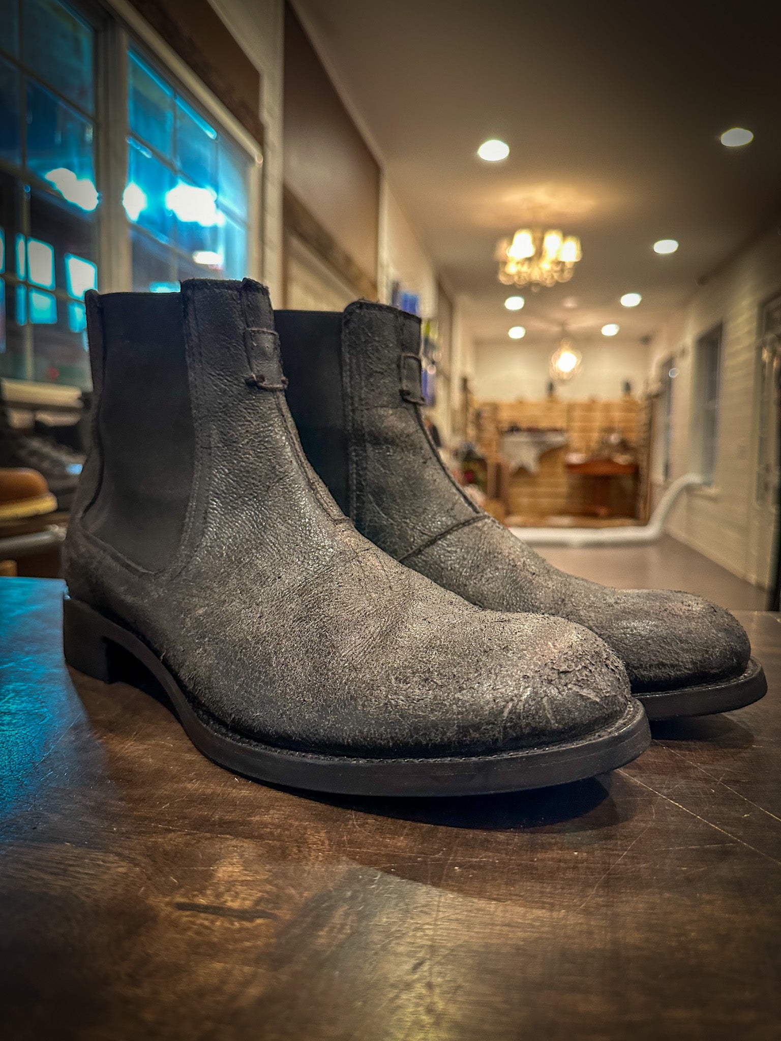 A pair of grey Chelsea Frye Boots repaired with the vibram 430 mini lug sole in black at the boot repair center