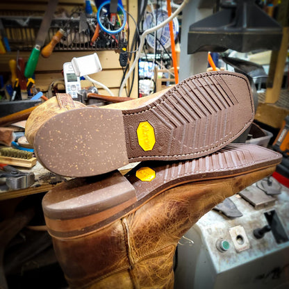 a pair of Ariat Cowboy Boots after being repaired with new Vibram 700 Tygum soles and heels at The Cowboy Boot Repair Center