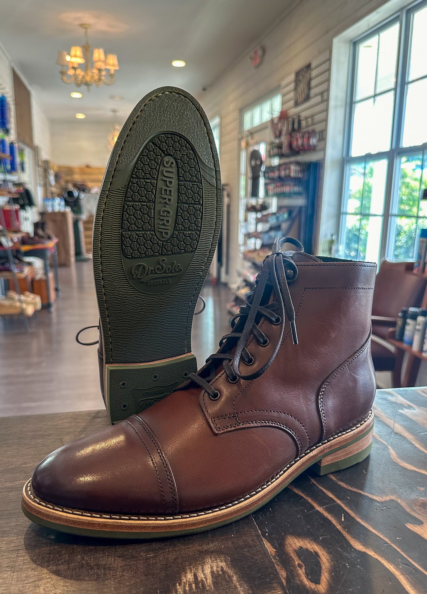 A pair of Thursday Captain Boots in the color Brandy customized with Dr Sole Green Full Soles and Heels