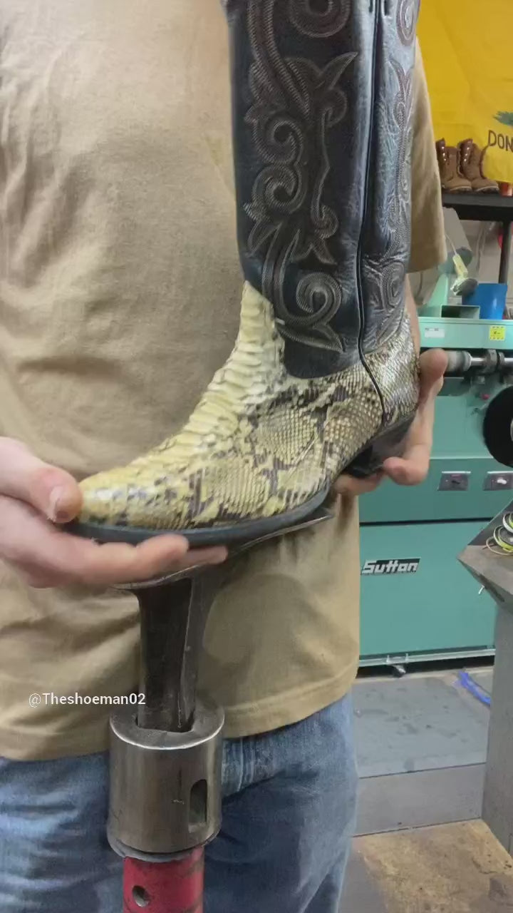 Load video: A pair of Vintage Tony Lama lizard skin cowboy boots being repaired with new leather soles at the cowboy boot repair center.