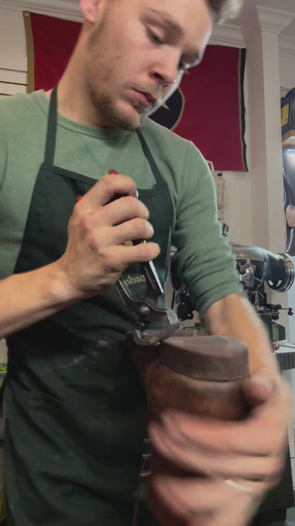 A pair of Redwing Iron Ranger Boots being repaired with new Vibram 100 soles and heels at the Redwing Boot repair center